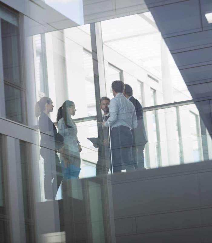 Group of businesspeople interacting in corridor of an office building